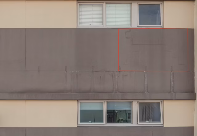 RGB visual survey identifying a long vertical structural crack on a grey rendered apartment facade