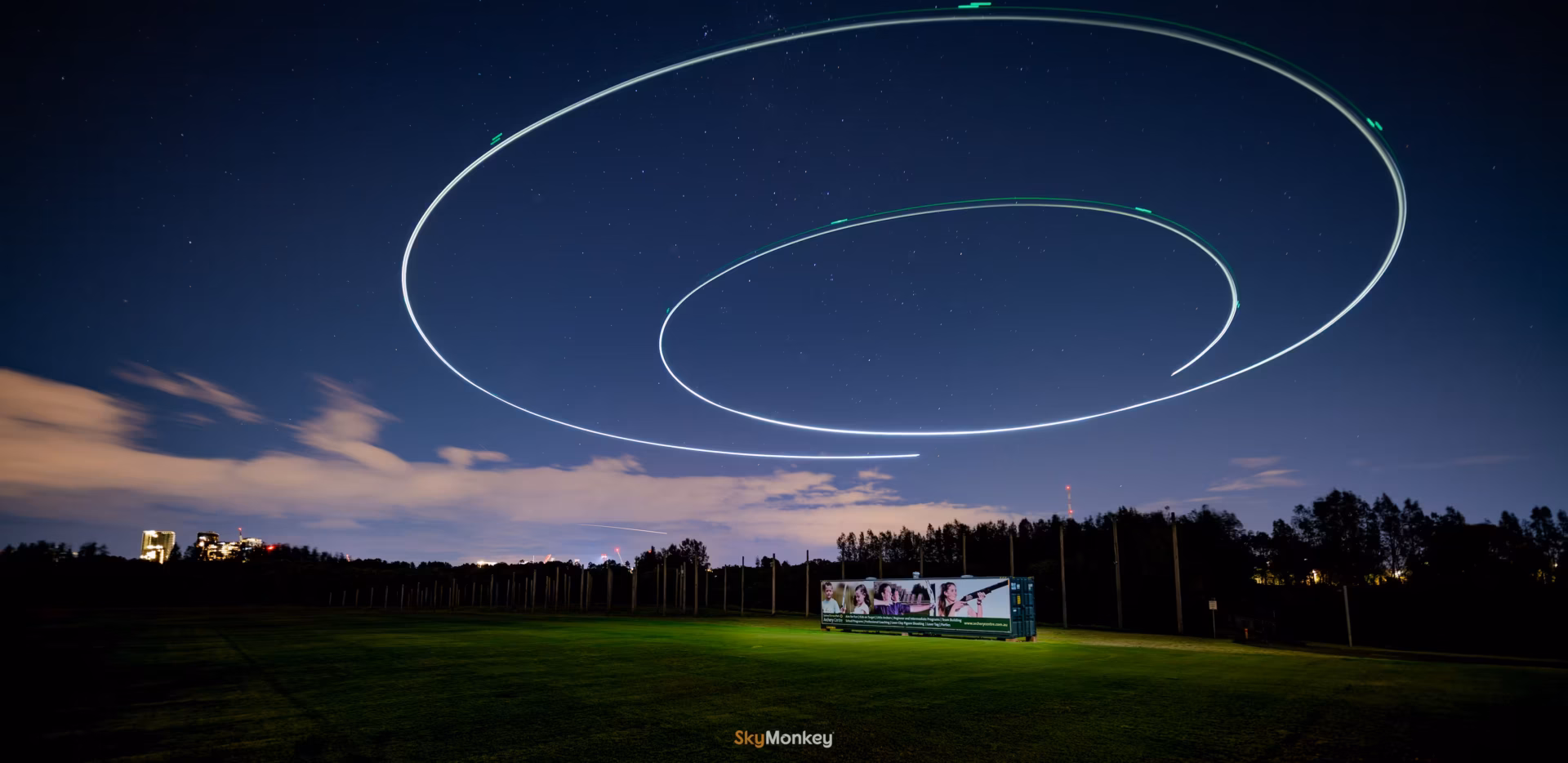 Creative photography at night using a long exposure professional camera of a drone flying in a spiral path, taken at Sydney Olympic Park Archery by Sky Monkey